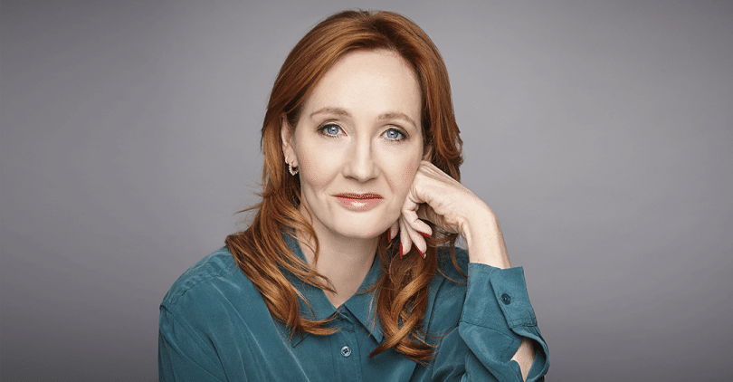 Autora J. K. Rowling com a mão apoiada no rosto.